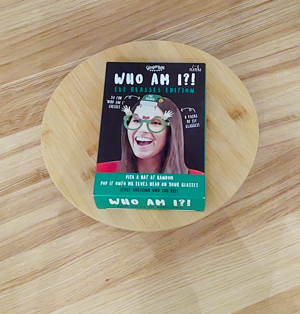 Het bordspel Who am I, Elf Glasses Edition op een rond plateau op een tafel. 