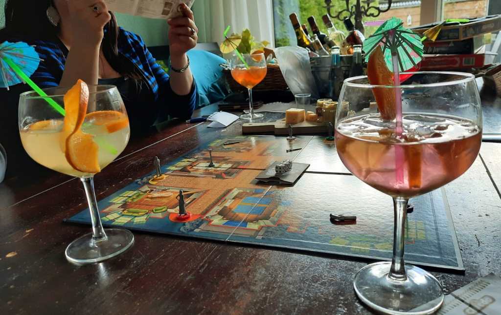 Tafel met het bordspel Cluedo en cocktails. 