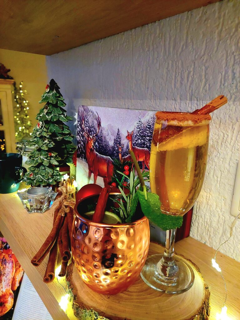 Twee kerst cocktails op een plank met een Schot tartan koekblik op de achtergrond.