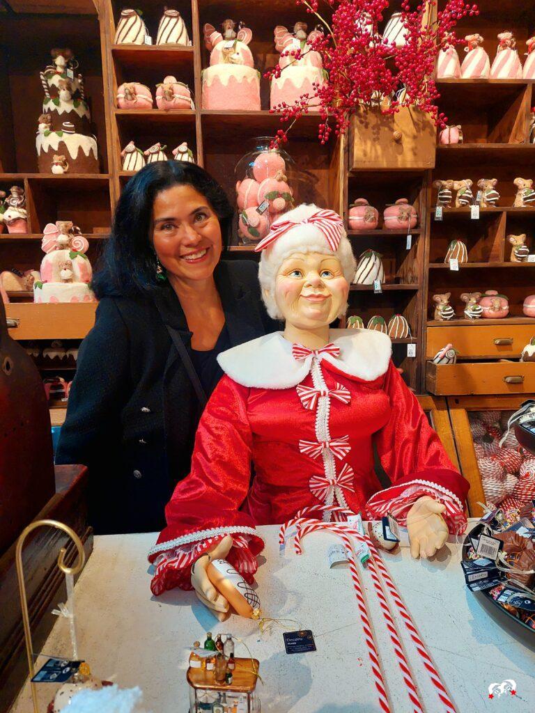 Carmen achter de toonbank bij Mrs. Claus met scandinavische kerstdecoratie. 