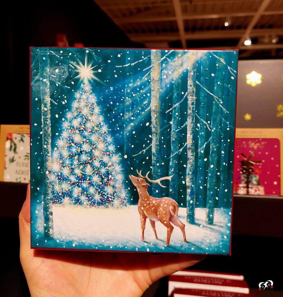 Kerstkaart met een kerstboom en een rendier