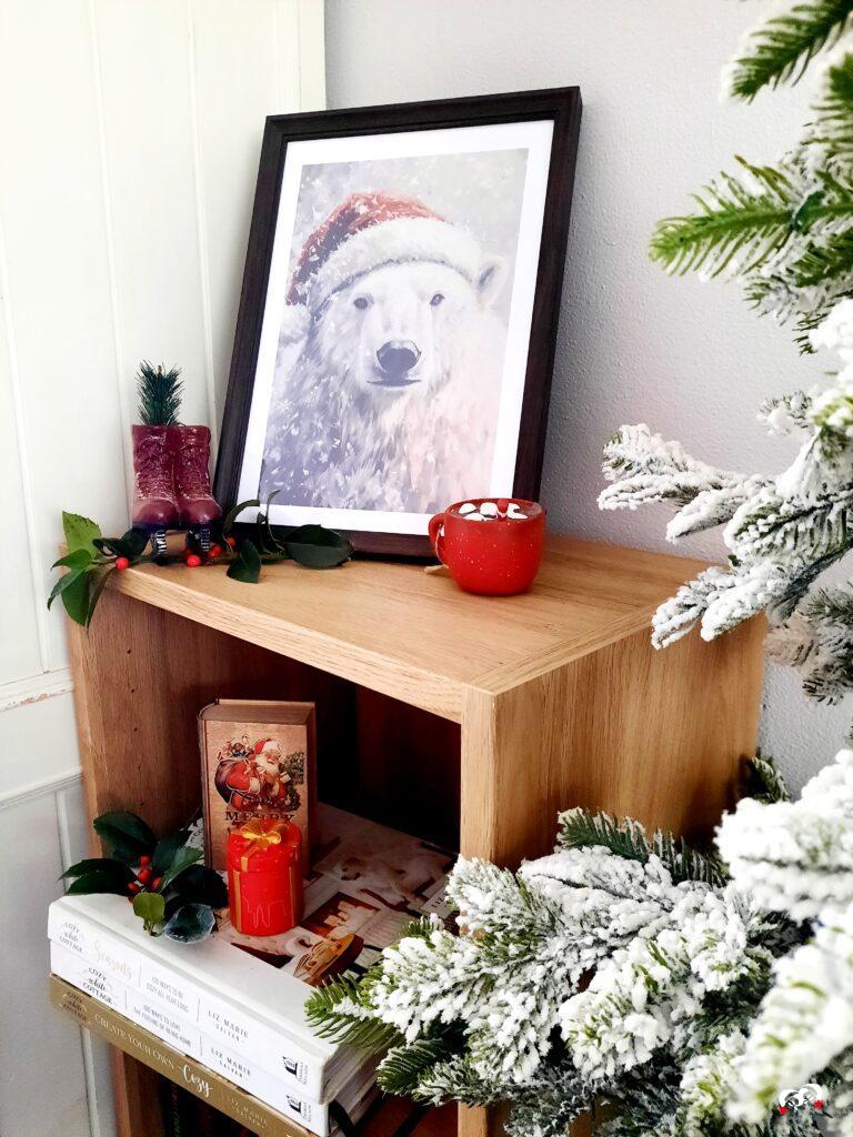 Boekenkastje met kookboeken, een kerstsposter in een lijst en kerstdecoratie