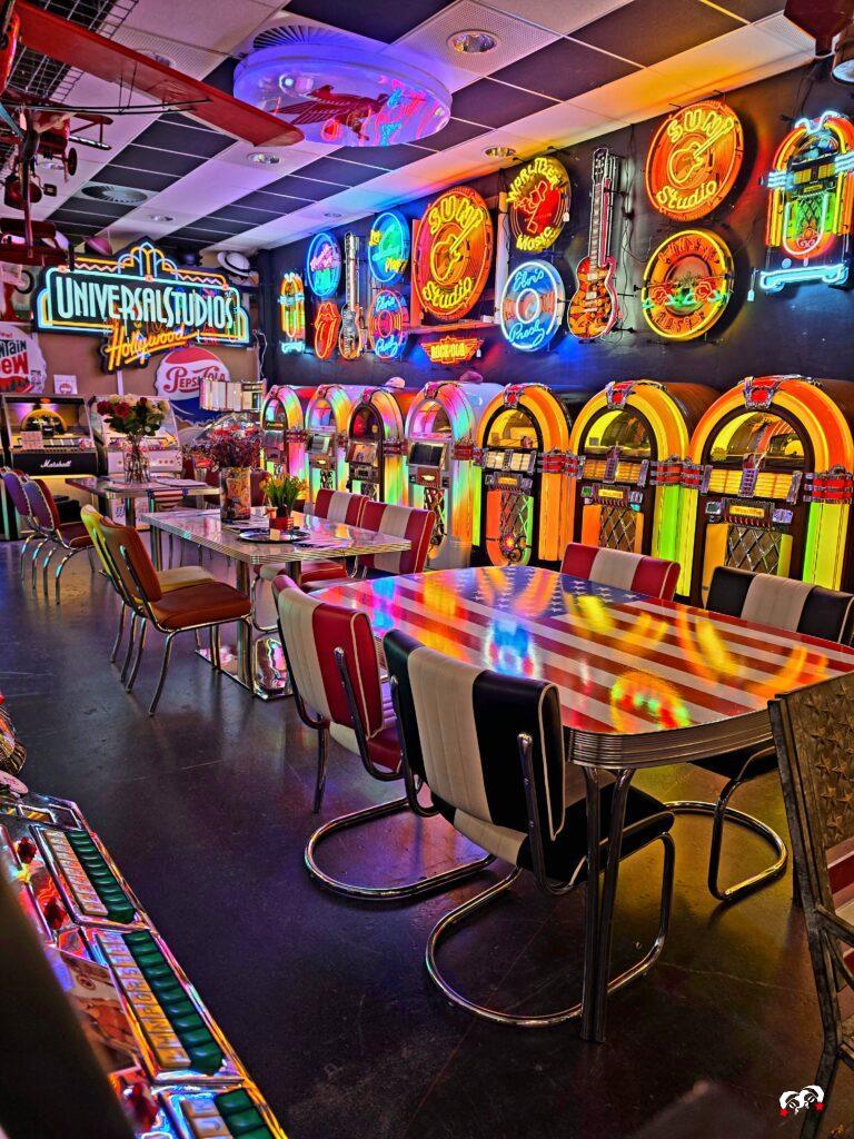 Overzicht van jukeboxen, een Universal Studios-bord en tafels in Amerikaanse diner-stijl.