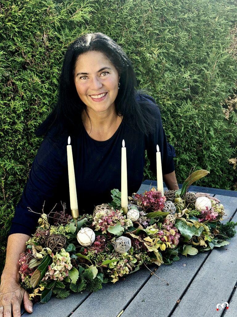 Carmen met haar zelfgemaakte herfst tafelstuk met hortensia’s, takken en kaarsen